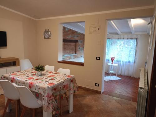 a dining room with a table and chairs and a window at Per chi ama mare e montagna! in Camaiore