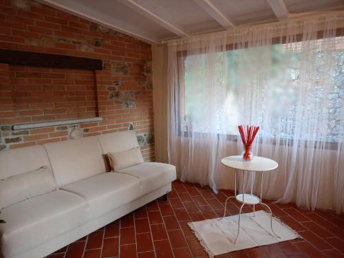 sala de estar con sofá blanco y ventana en Per chi ama mare e montagna!, en Camaiore