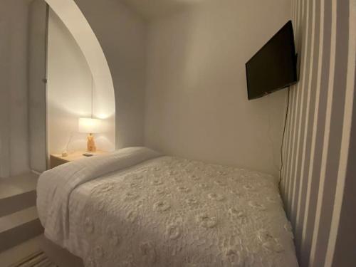 a small bedroom with a bed and a television at Casa Alta T0 in Castelo de Vide