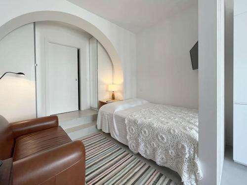 a bedroom with a bed and a couch and a chair at Casa Alta T0 in Castelo de Vide