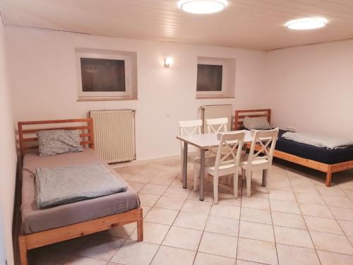 a room with two beds and a table and chairs at SOUTERRAIN Monteur Arbeiter 2-Zimmer Wohnung in KASSEL in Kassel