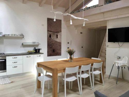 uma cozinha e sala de jantar com uma mesa de madeira e cadeiras em Appartamento Al Garibaldi em Levico Terme