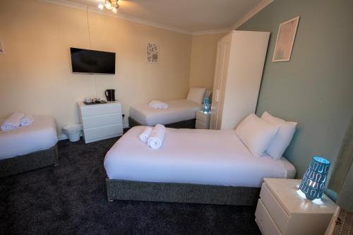 a hotel room with two beds and a tv at Irvine Riverside Guesthouse - Full House in Irvine