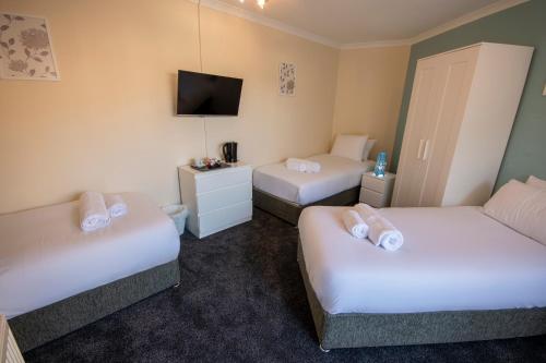um quarto de hotel com duas camas e uma televisão em Irvine Riverside Guesthouse - Full House em Irvine