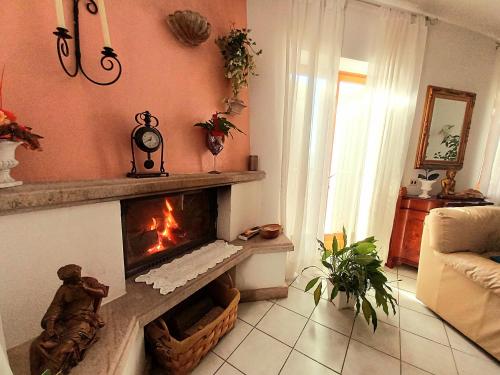 a living room with a fireplace and a couch at La Maison des Rèves -Langhe Piemonte in Torre Bormida