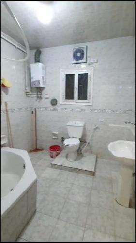 e bagno con servizi igienici, lavandino e vasca. di شقة مفروشة مميزة جدا a Mît Khamîs