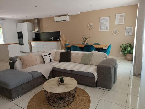 ein Wohnzimmer mit einem Sofa und einem Tisch in der Unterkunft Villa aiguës marines in Pérols