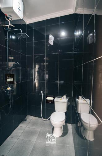 un baño con inodoro y lavabo en Villa HBNR Two-Bedroom Tiny House with Private Pool in Bali, en Babakan Sangsit