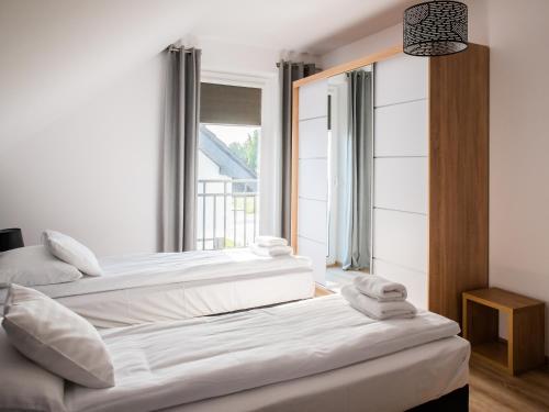 two beds in a room with a window at Osada Nord domki wypoczynkowe in Jastrzębia Góra