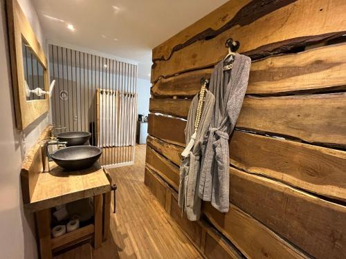 a bathroom with a wooden wall at Les Bruyeres Chambres dhotes et Gite in Verteuil-sur-Charente