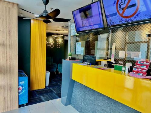 un ristorante con bancone giallo e TV di Seeds Hotel PV128 Setapak a Kuala Lumpur