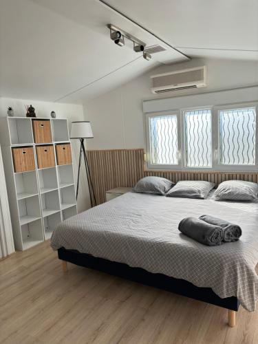 a bedroom with a large bed and two windows at Chalet nature proche plage in La Ciotat