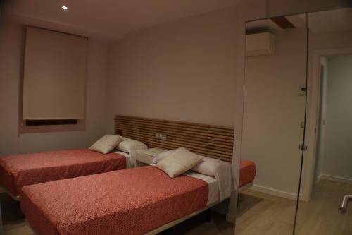 a room with two beds and a mirror at APARTAMENTOS PICOS DE EUROPA in Santander