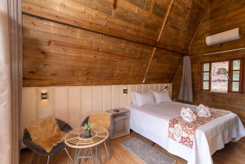 a bedroom with a bed and a table in a room at Pousada Dona Carmita in Brumadinho