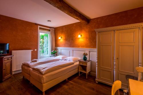 a bedroom with a bed and a window at Auberge de Smockelaer in Heijenrath