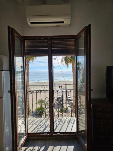 een open deur naar een balkon met uitzicht op het strand bij H&B COSTABLANCA in Villajoyosa