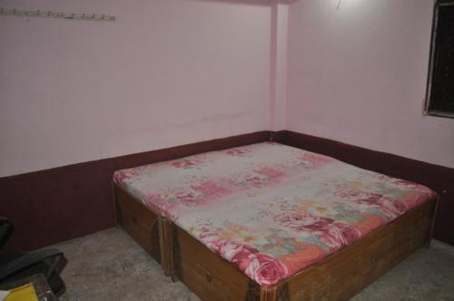 Cama pequeña en habitación con colchón de flores en Virndawan House en Maheshwar