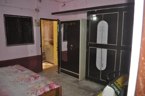 una habitación con 2 puertas y una habitación con 1 cama en Virndawan House en Maheshwar