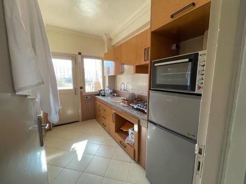 a kitchen with a white refrigerator and a sink at Fayb-Sweet-Home-4 - Cité Essalam in Agadir
