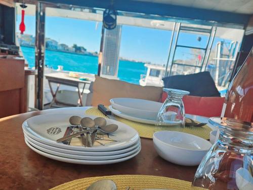 a table with plates and spoons on top of it at Nuit insolite bateau à quai - Port Saint Louis du Rhône in Saint-Louis-du-Rhône