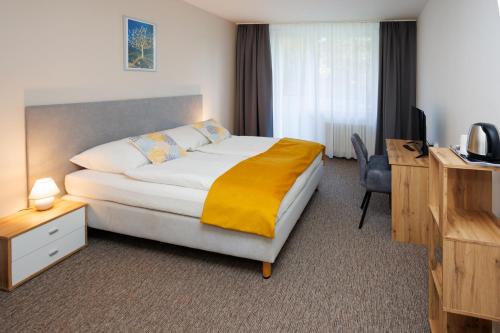 a hotel room with a bed and a desk at Hotel FIT in Přerov