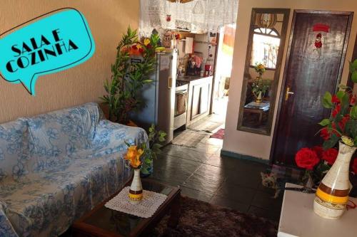 een woonkamer met een blauwe bank en een keuken bij Casa Temporada à Beira da Praia in Maricá