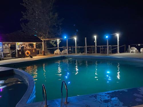 a swimming pool at night with lights at Cabaña Mirador Del Cielo Potrerillos in Potrerillos