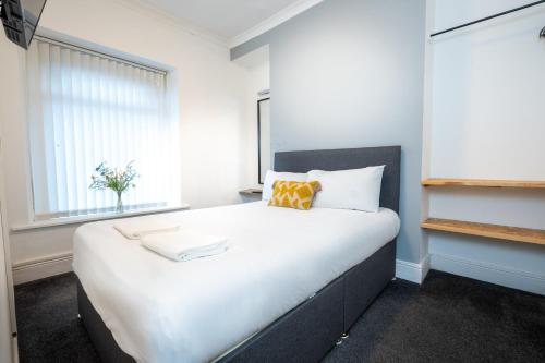 a bedroom with a large white bed with a window at 5-Bedroom home - Ideal for groups working away from home in Swansea