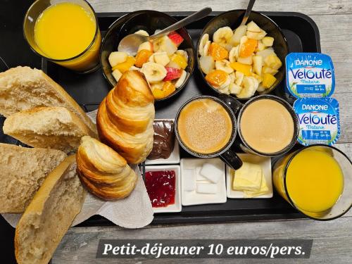 a tray of breakfast food with croissants bread and juice at Nuit insolite bateau à quai - Port Saint Louis du Rhône in Saint-Louis-du-Rhône