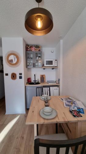 une cuisine avec une table en bois et une salle à manger dans l'établissement La cabane, à Huez