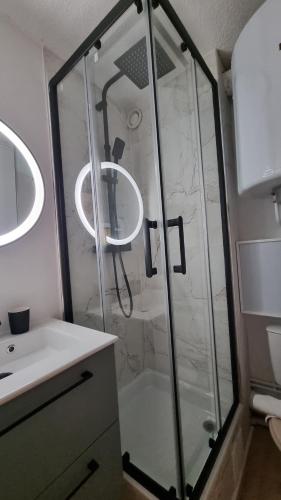 une douche avec une porte vitrée dans une salle de bain dans l'établissement La cabane, à Huez