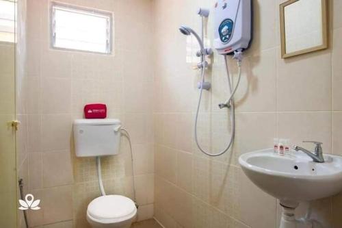 een badkamer met een douche, een toilet en een wastafel bij Langkawi Homestay Bunga Padi in Kuah