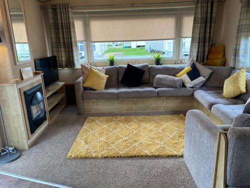 uma sala de estar com um sofá e uma lareira em Lancaster Crescent Hot Tub Hideaway em Tattershall