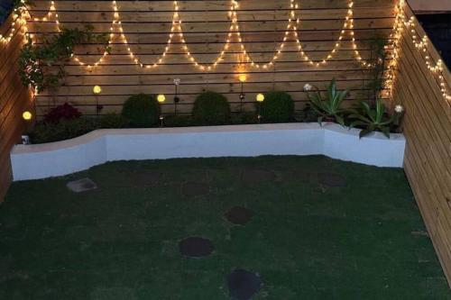 a garden with lights on a wooden fence at 陌上花民宿 電麻switch烤肉抓周派對 in Hualien City