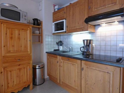 a kitchen with wooden cabinets and a microwave at Appartement Le Grand-Bornand, 2 pièces, 6 personnes - FR-1-458-197 in Le Grand-Bornand