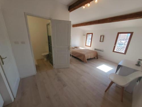une chambre avec un lit, un bureau et une chaise dans l'établissement Studio Cosy en plein centre ville, à Bédarieux