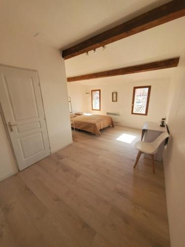 - une chambre avec un lit, une table et une porte dans l'établissement Studio Cosy en plein centre ville, à Bédarieux