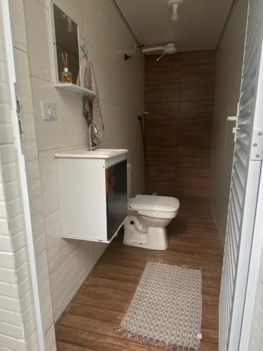 a small bathroom with a toilet and a sink at Casa Guarujá próx. Balsa Santos in Guarujá