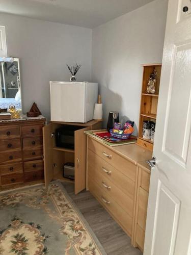a kitchen with wooden cabinets and a counter top at Beautiful new Garden Annexe in Ashton in Makerfield