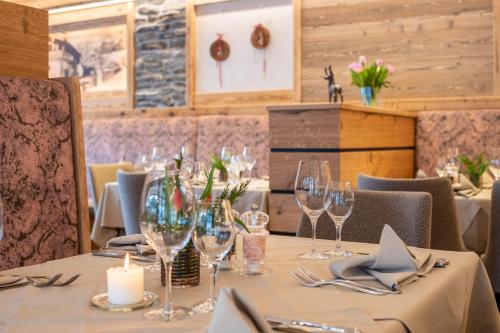 a dining room with a table with wine glasses at Hotel Jagdschlössl in Kirchdorf in Tirol