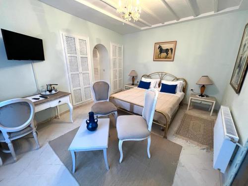 a bedroom with a bed and a desk and a tv at Dar Yessine Boutique Hôtel in Sousse