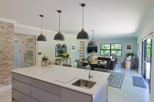 an open kitchen and living room with pendant lights at Saffron House in Hermanus