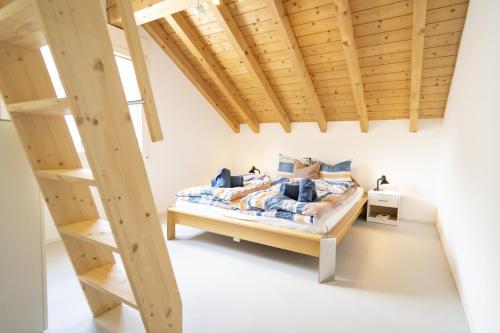 1 dormitorio con 1 cama con techo de madera en Chasa Stradun 400, en Scuol