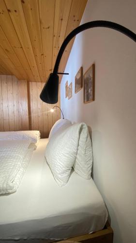 a bedroom with two white beds and a black lamp at Bergquelle 1.OG in Bettmeralp