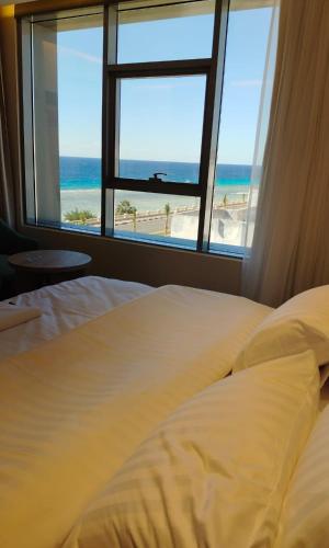a bedroom with a bed and a view of the beach at فندق سي قل - Sea gull Hotel in Umm Lujj