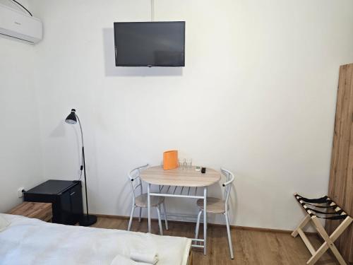 Casa Dragoste في Someşu Cald: طاولة صغيرة وكراسي في غرفة مع تلفزيون