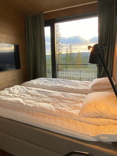 een slaapkamer met een bed en een raam met uitzicht bij Modern villa in North Park Villas, Idre in Idre