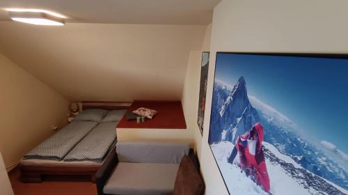 a small room with a bed and a large tv at Guest House Sherpa in Moravská Třebová