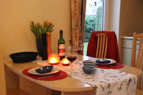 Una mesa con una botella de vino y dos copas. en 4 Sterne Apartment Seeschwalbe mit Sauna und Terrasse, en Lobbe