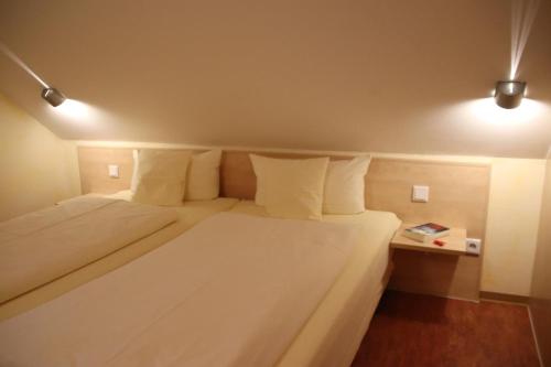 Un dormitorio con una gran cama blanca con dos almohadas. en 4 Sterne Apartment Greifswalder Oie mit Balkon, en Lobbe